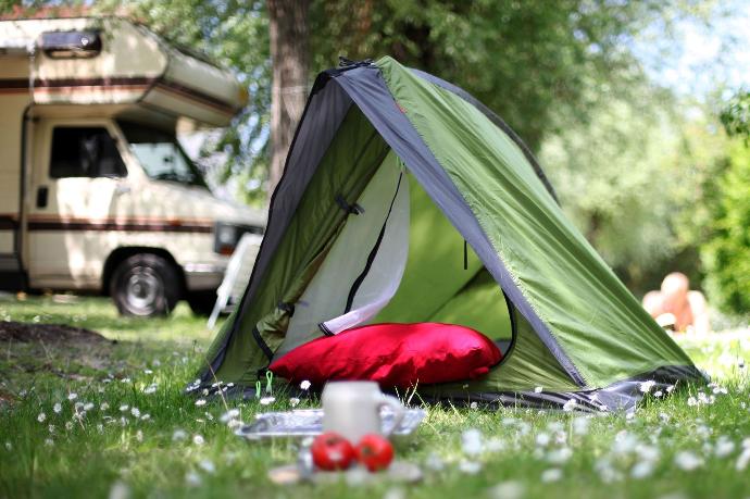 Une tente verte plantée dans un camping symbolisant les hébergements touristiques