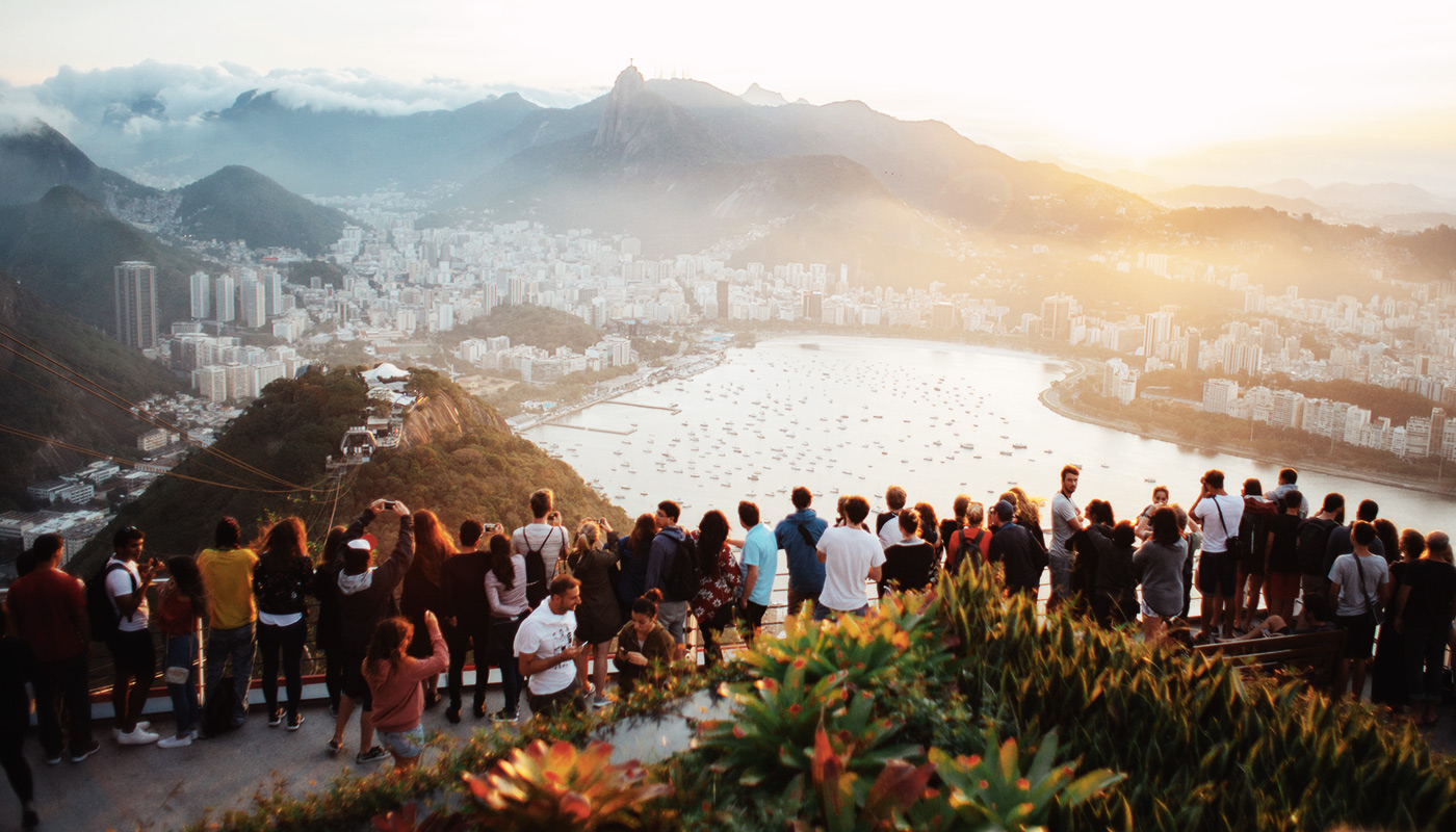Un groupe d'une trentaine de personne regardent la baie de Rio depuis un point de vue place incontournable du tourisme mondial